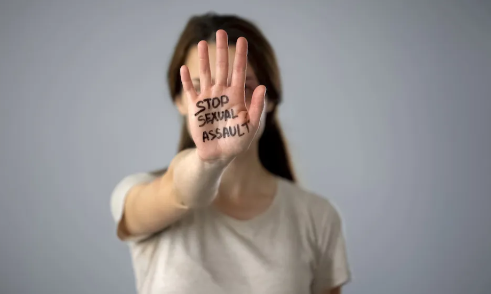 A woman with the words, "STOP SEXUAL ASSAULT," on her palm.