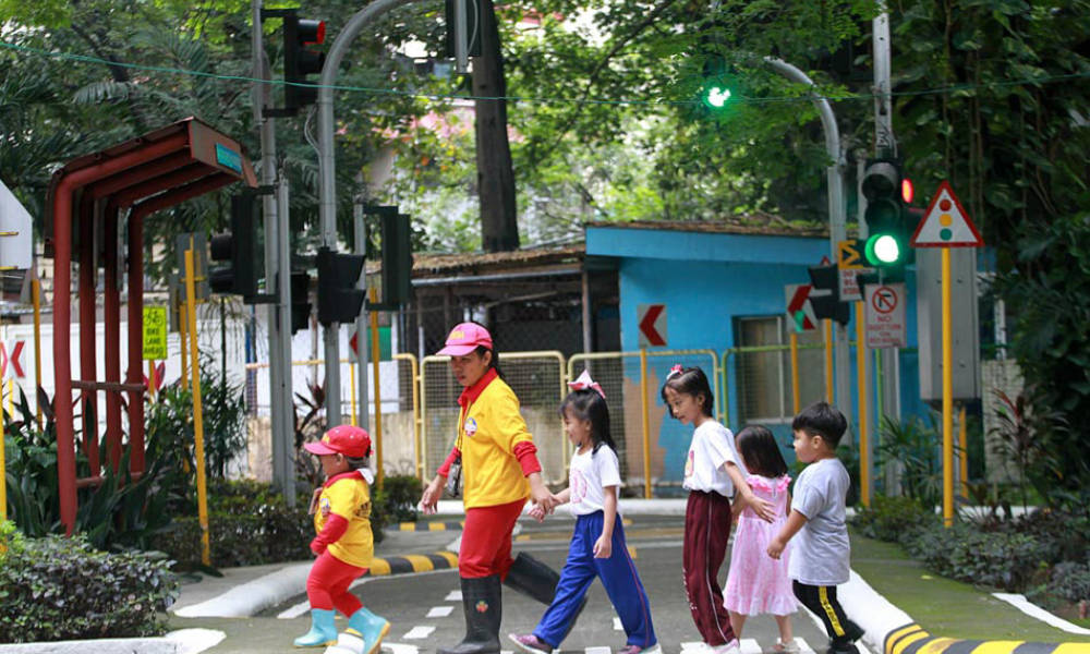 A woman teaching children proper street smarts.