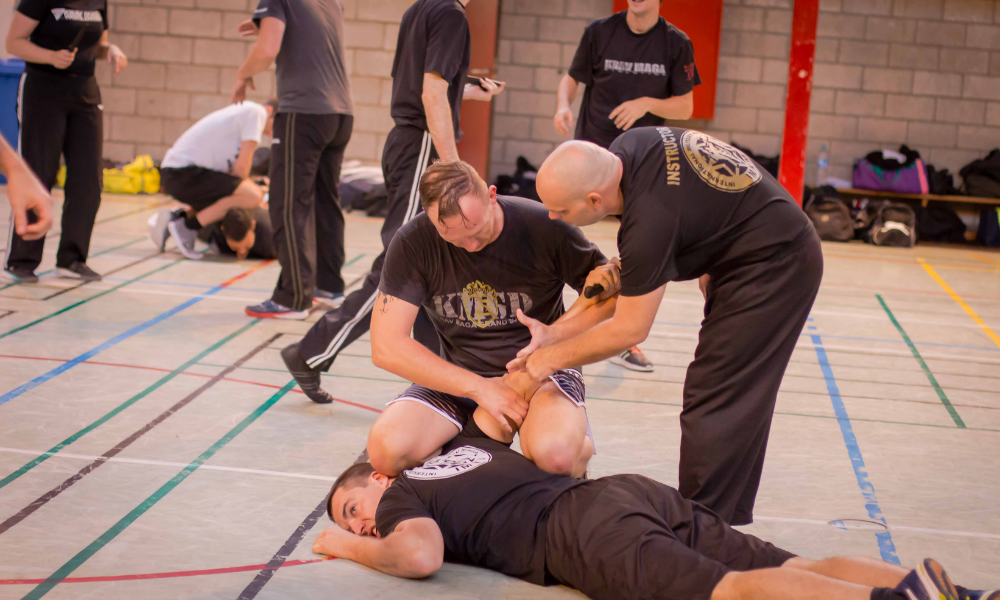 An instructor helping a Krav Maga practitioner understand the principles of the martial art.