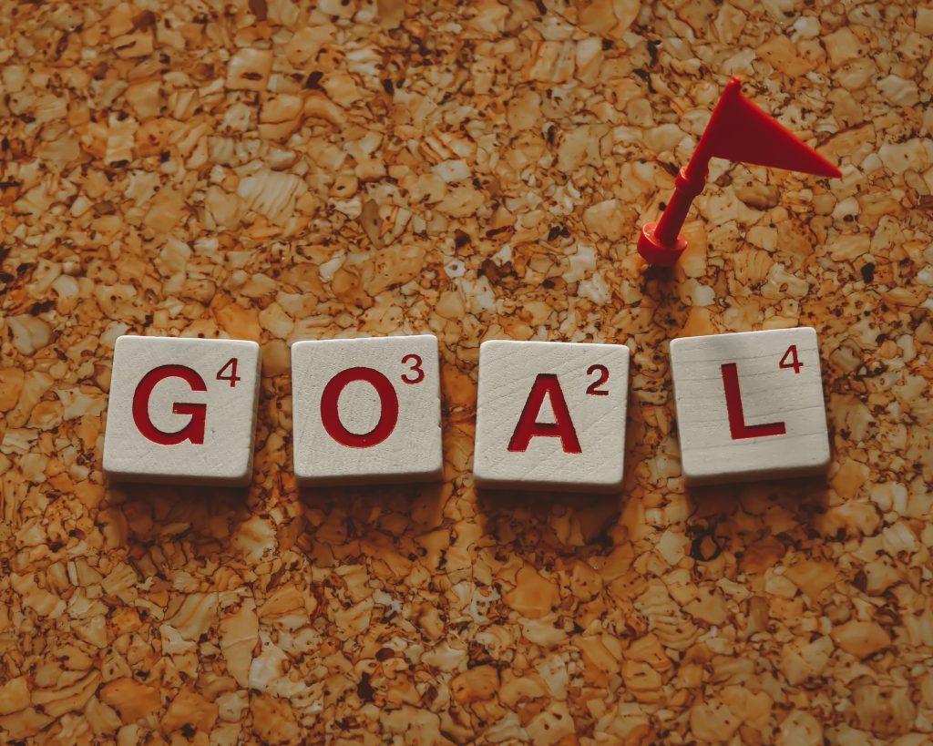 Scrabble letters spelling out the word, "GOAL."