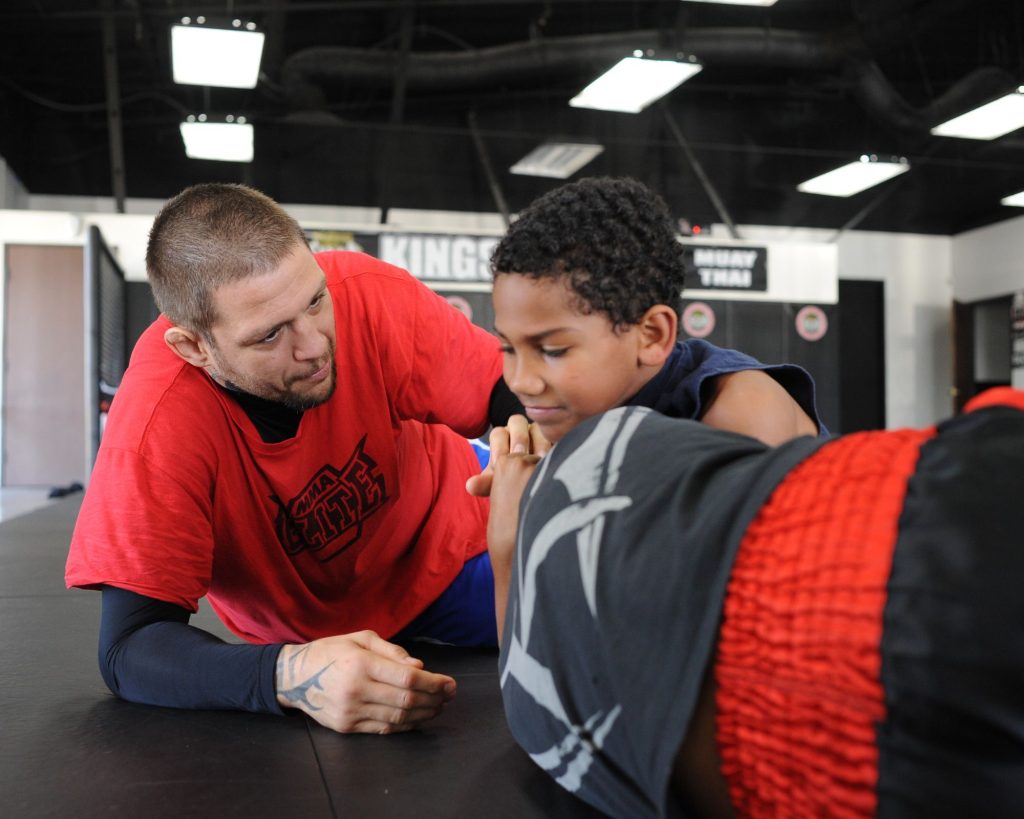 A young man being taught BJJ.