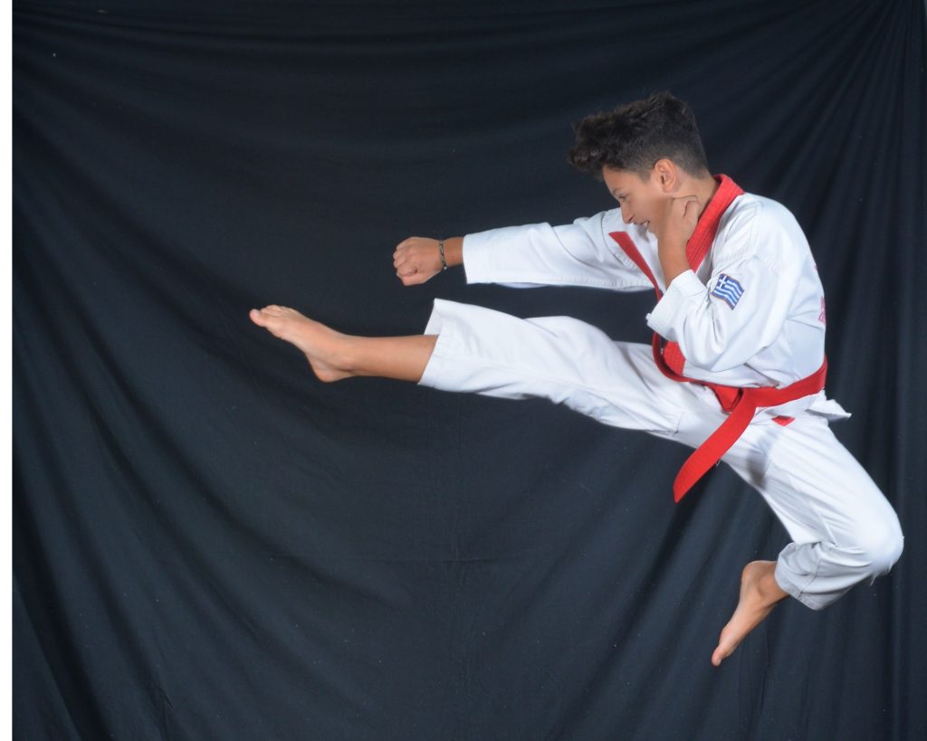 A child performing a taekwondo kick.